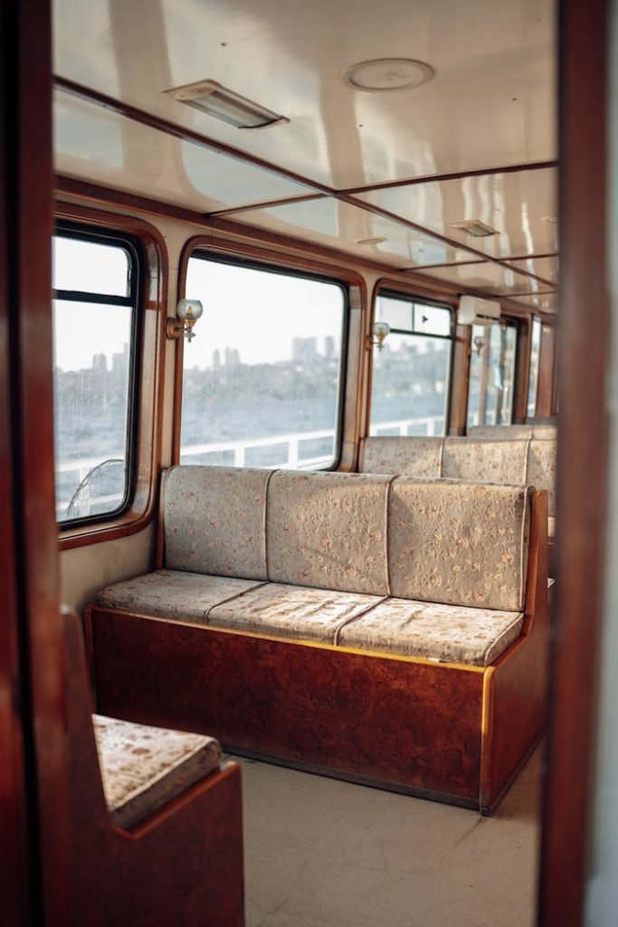 The Art of Drawing Readers In: Your attractive post title goes here Interior shot of an empty ferry with vintage seating and wooden accents, overlooking cityscape.
